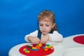 A child concentrates constructing a house from a designer