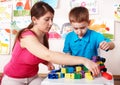 Child with construction in play room.