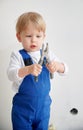 Little boy with pliers standing in apartment under renovation.