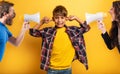 Child covers his ears because he does not want to hear the cries and reproaches of his parents. Yellow background Royalty Free Stock Photo