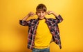 Child covers his ears because he does not want to hear noise. Yellow background