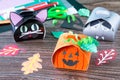 The child creates a gift box of a black cat of Halloween, a Halloween pumpkin and a vampire box.