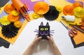 The child creates a gift box of a black cat. A party for Halloween.