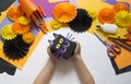 The child creates a gift box of a black cat. A party for Halloween.