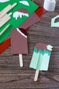 The child creates a gift of paper chocolate popsicle and mint popsicle. Made by hand.