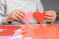The child creates a hearts out of paper, hands close-up. Origami for Valentine& x27;s Day. Royalty Free Stock Photo