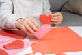 The child creates a hearts out of paper, hands close-up. Origami for Valentine& x27;s Day. Royalty Free Stock Photo