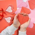 The child creates a hearts out of paper, hands close-up. Origami for Valentine& x27;s Day. Royalty Free Stock Photo