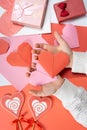 The child creates a hearts out of paper, hands close-up. Origami for Valentine's Day. Royalty Free Stock Photo