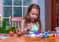 Child creating colorful art on rocks