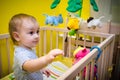 Child in the crib playing with a toys