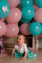 The child cries, gets angry, a little girl, a child, sits on the floor and cries, wrinkled her nose, near the balloons, a holiday. Royalty Free Stock Photo