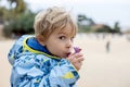 Child, cute boy, playing with ceramic clay whistle in the form of bird, souvenir from park Guell in Barcelona Royalty Free Stock Photo