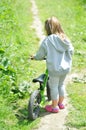 Child cute little girl riding bike in forest Royalty Free Stock Photo