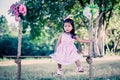 Child cute little girl sitting on swing in the park Royalty Free Stock Photo