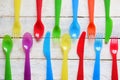 Child cutlery on a white wooden table in a kindergarten. Colorful flatware