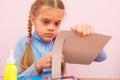 Child cuts a strip of cardboard in the classroom