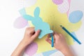 Child cutting out easter bunny with scissors.