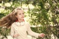 Child dance to music in summer park. Small girl enjoy music in headphones outdoor. Kid dancer with long flying hair Royalty Free Stock Photo