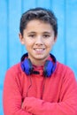 Child with dark hair listening music with blue headphones