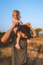 Child daughter sitting on father shoulders walking outdoor family playing together