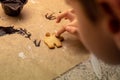 Child decorates biscuits with coloured sprinkles and chocolate