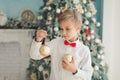 Child decorating Christmas tree at home. Boy hangs Christmas balls on tree. Christmas Eve concept Royalty Free Stock Photo