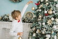 Child decorating Christmas tree at home. Boy hangs Christmas balls on tree. Christmas Eve concept Royalty Free Stock Photo