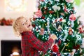 Child decorating Christmas tree. Kid on Xmas eve Royalty Free Stock Photo