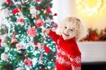 Child decorating Christmas tree. Kid on Xmas eve. Royalty Free Stock Photo