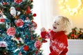 Child decorating Christmas tree. Kid on Xmas eve. Royalty Free Stock Photo