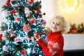 Child decorating Christmas tree. Kid on Xmas eve Royalty Free Stock Photo