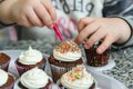 child decorating cupcakes with sprinkles Royalty Free Stock Photo