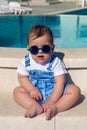 Child in denim suit sitting next to the pool Royalty Free Stock Photo