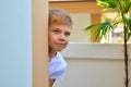 The child detective. Child spies and watches. A boy looks out from behind the wall. hide and seek on the street