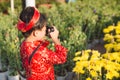 Child with digital compact camera outdoors. Cute little Vietnamese boy in ao dai dress. Tet holiday Royalty Free Stock Photo