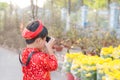 Child with digital compact camera outdoors. Cute little Vietnamese boy in ao dai dress. Tet holiday Royalty Free Stock Photo