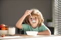 Child dinner. Portrait of fun kid having healthy tasty snack. Small kid crazy posing by kitchen table.