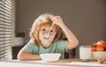 Child dinner. Portrait of fun kid having healthy tasty snack. Small kid crazy posing by kitchen table.