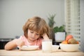 Child dinner. Portrait of fun kid having healthy tasty snack. Small kid crazy posing by kitchen table.