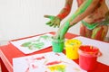 Child dipping fingers in washable finger paints