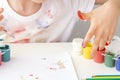 Child dips his fingers into jars of paint, gouache. Palms painted on childrens hands with multi-colored paints. Childs hobby Royalty Free Stock Photo