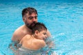 child with disability laughs and plays in his father& x27;s arms in a swimming pool Royalty Free Stock Photo