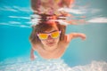 Child dives into the water in swimming pool. little kid swim underwater in pool. Child swimming underwater in sea or