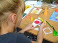 The child does applique of color paper. Children`s master class in the open air