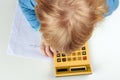 Child does calculations with retro calculator Royalty Free Stock Photo