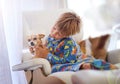 Child, dog and animal playing on sofa for bonding together, connection or adoption in living room. Young boy, pet puppy Royalty Free Stock Photo