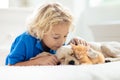 Child, dog and cat. Kids play with puppy, kitten