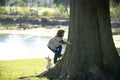 Child with dog climb a tree, kid playing with puppy in a park and climbing. Owner and pet having fun in garden outdoors Royalty Free Stock Photo