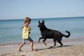 Child with dog outdoors on beach Royalty Free Stock Photo